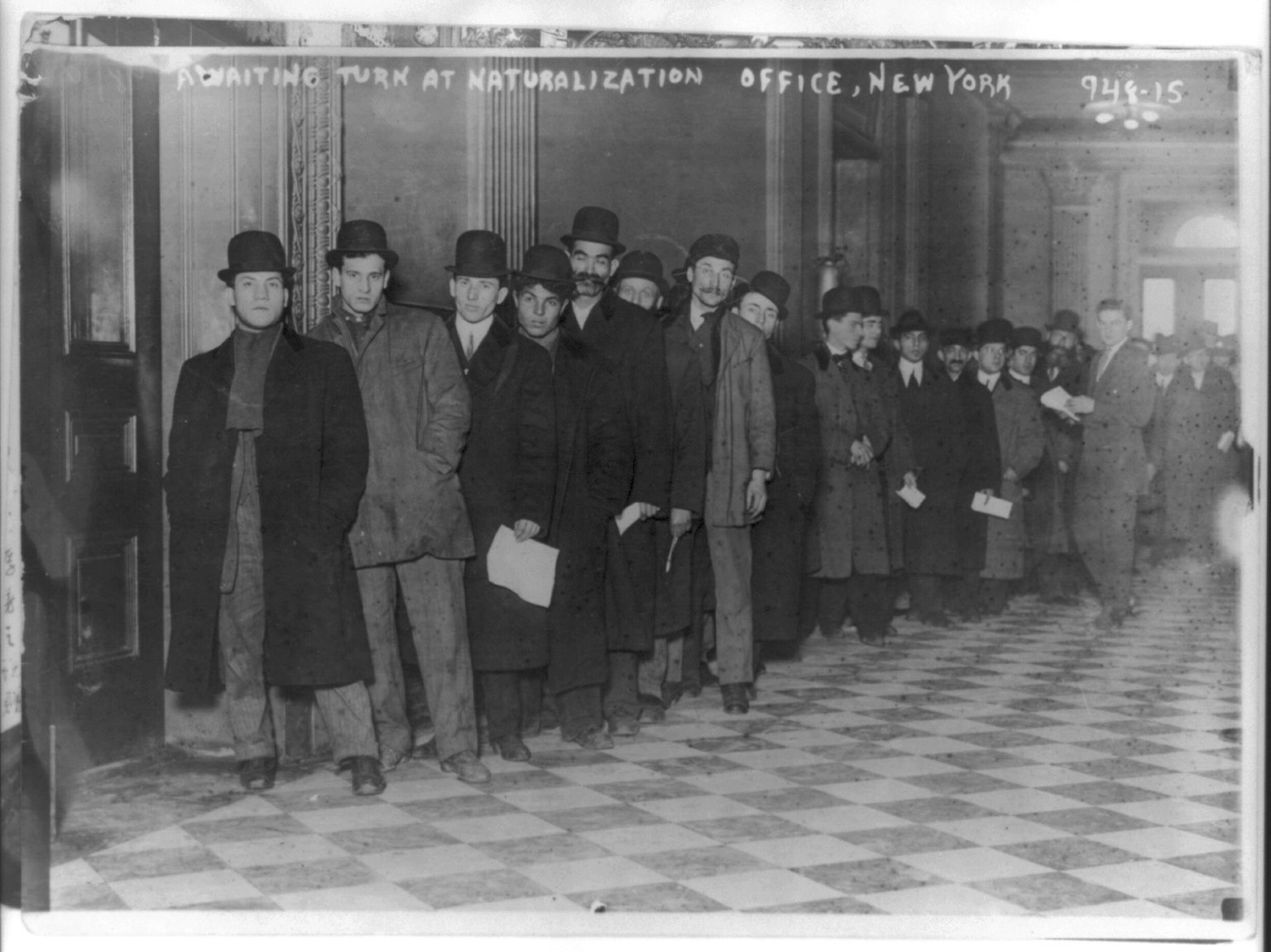 Men and women seated waiting at a New York naturalization office in 1916
