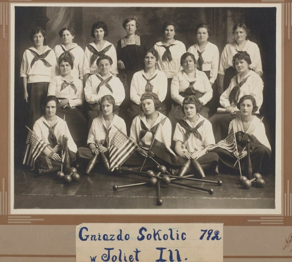 Group portrait of Polish Falcons women in Joliet, Illinois, 1923, with flags and Indian clubs